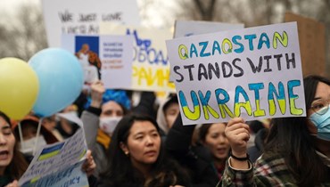 متظاهرون يحملون لافتات في ألماتي خلال مسيرة لدعم أوكرانيا (6 آذار 2022، أ ف ب). 
