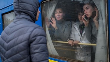 عائلة في قطار إجلاء تودع شابا في محطة القطارات المركزية في أوديسا بأوكرانيا (6 آذار 2022، ا ف ب). 