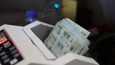 صورة تُظهر آلة احتساب النقود لدى صرّاف في بيروت (حسام شبارو).
