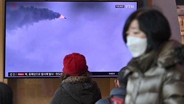 اشخاص يتابعون بثًا إخباريًا لتجربة صاروخ كوري شمالي على شاشة تلفزيون في محطة قطارات في سيول (5 آذار 2022، أ ف ب). 