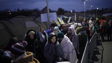 لاجئون فارون من الحرب في أوكرانيا يصطفون عند معبر ميديكا الحدودي في بولندا (10 آذار 2022، ا ب). 