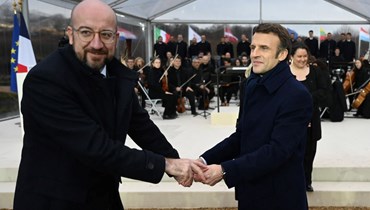 ماكرون (إلى اليمين) وميشال يحضران الاحتفال باليوم الوطني والأوروبي لإحياء ذكرى ضحايا الإرهاب، في غران تريانون بالقرب من قصر فرساي جنوب غرب باريس (11 آذار 2022، ا ف ب). 