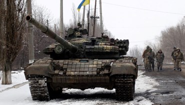 جنود أوكرانيون خلال توجههم إلى موقع في منطقة لوغانسك (11 آذار 2022، ا ف ب). 