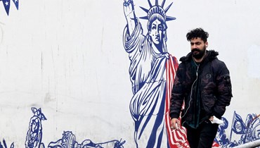 إيراني يمر قرب جدارية مناهضة للولايات المتحدة على جدار المقر السابق للسفارة الاميركية في طهران (12 آذار 2022، أ ف ب).