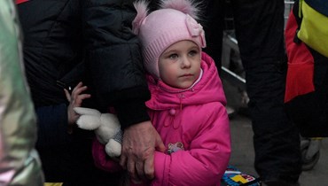 طفلة تمسك بيد جدتها بعد عبور الحدود الأوكرانية مع بولندا عند المعبر الحدودي في ميديكا جنوب شرق بولندا (14 آذار 2022، أ ف ب). 