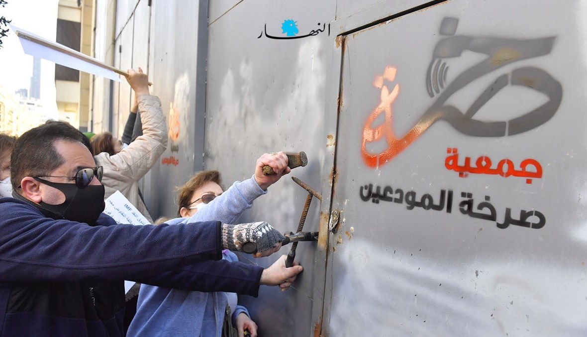 أعضاء في جمعية المودعين في وسط بيروت حيث كتبوا على بواباتها شعارات تندد ببسرقة الودائع وإفقار الناس.