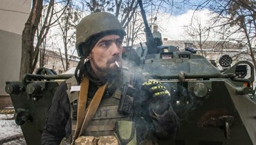 متطوع من قوات الدفاع الإقليمية الأوكرانية يقف بجوار حاملة جنود مدرعة في خاركيف بأوكرانيا (16 آذار 2022، ا ب). 