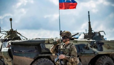 جندي أميركي يقف بالقرب من ناقلة جند روسية في محافظة الحسكة - "أ ف ب"