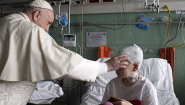 البابا فرنسيس يبارك طفلاً جريحا في جناح يعالج فيه أطفال وصلوا من أوكرانيا، خلال زيارته مستشفى بامبينو جيسو للأطفال في روما (19 آذار 2022، أ ف ب). 