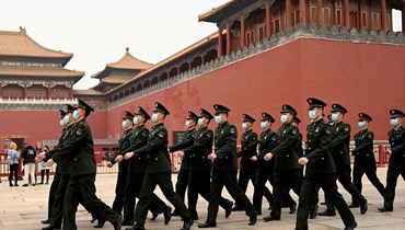 رجال أمن يمرون أمام مدخل المدينة المحرمة في بيجينغ (11 آذار 2022، أ ف ب). 
