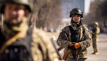 جنود أوكرانيون يقفون في حراسة عند نقطة تفتيش عسكرية في كييف (21 آذار 2022 - أ ف ب).