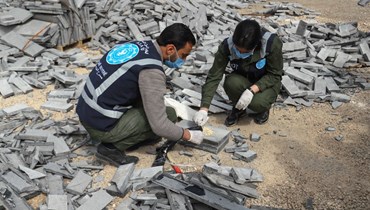 عنصران من الأسايش يكشفان مخدرات مخبأة في مواد بناء في مستودع في مدينة القامشلي شمال شرق سوريا (22 آذار 2022، أ ف ب). 