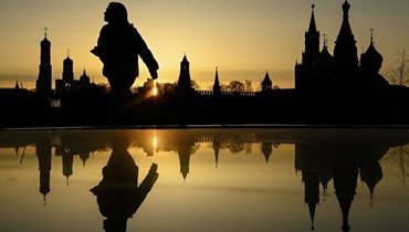 امرأة تمشي أمام كاتدرائية إيفان الكبرى وبرج سباسكايا في الكرملين (أ ف ب). 