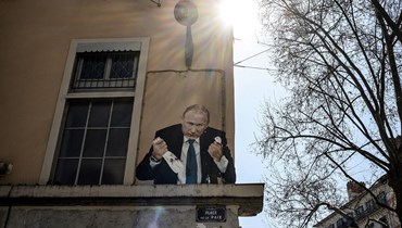صورة تظهر لوحة تصور الرئيس الروسي فلاديمير بوتين وهو يقتل حمامة ، في ساحة بلاس دي لا باي في ليون ، وسط شرق فرنسا، في 22 آذار 2022 (أ ف ب). 