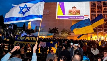 إسرائيليون يتابعون خطاب زيلينسكي للكنيست عبر شاشة عملاقة في تل أبيب الأحد (أ ف ب).