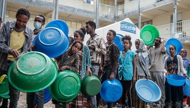 أشخاص فروا من العنف في منطقة تيغراي الإثيوبية ينتظرون تلقي الطعام في مدرسة تستضيف نازحين في ميكيلي (19 حزيران 2021، أ ف ب). 