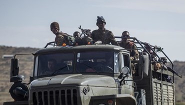 صورة ارشيفية- جنود إثيوبيون جلسوا في مؤخرة شاحنة خلال سيرها على طريق قرب أغولا شمال ميكيلي في منطقة تيغراي شمال إثيوبيا (8 ايار 2021، أ ب). 
