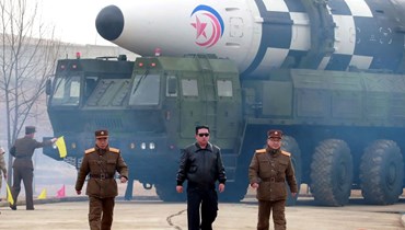 كيم (في الوسط) يمر قرب ما يقول تقرير وسائل الإعلام الحكومية إنه نوع جديد من الصواريخ البالستية العابرة للقارات (24 آذار 2022، ا ف ب). 