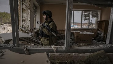 جندي أوكراني وقف في مبنى متضرر في ستويانكا بأوكرانيا (27 آذار 2022، أ ب).