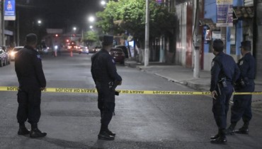 عناصر من الشرطة انتشروا في موقع جريمة قتل رجل على يد افراد عصابة مزعومين في كولون بمقاطعة لا ليبرتاد في السلفادور (26 آذار 2022، أ ف ب).