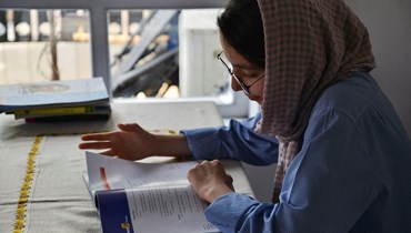 طالبة أفغانية تدرس (أ ف ب).
