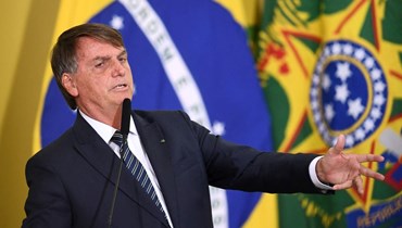بولسونارو خلال احتفال إطلاق عمليات التسليم الجديدة لبرنامج  "الدخل والفرص" في بالاسيو دو بلانالتو في برازيليا (25 آذار 2022، أ ف ب). 