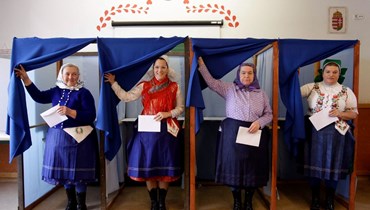 نساء بثياب هنغارية تقليدية يقترعن في مدرسة في فيريزيجيهاز  شرق بودابست خلال الانتخابات العامة (3 نيسان 2022، أ ف ب).