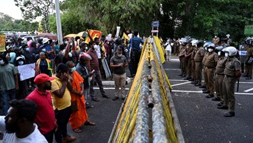شرطيون في مواجهة متظاهرين يحتجون على الازمة الاقتصادية بالقرب من مبنى البرلمان في كولومبو (5 نيسان 2022، أ ف ب). 