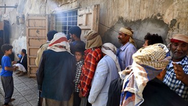 يمنيون ينتظرون بالصف لتلقي وجبة إفطار مجانية في صنعاء خلال شهر رمضان المبارك (4 نيسان 2022، أ ف ب). 
