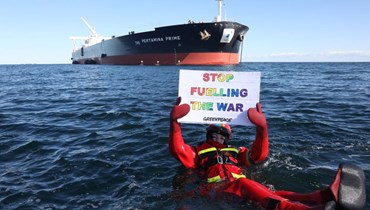 صورة قدمتها منظمة "غرينبيس" وتظهر أحد نشطائها وهو يحمل لافتة مناهضة للحرب، بينما طفا أمام الناقلة العملاقة "بيرتامينا برايم" قبالة سواحل الدانمارك (31 آذار 2022، أ ف ب). 