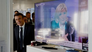 ماكرون يشاهد مقابلة لمنافسته لوبن قبيل الانتخابات الرئاسية الفرنسية (أ ف ب).