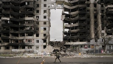 جندي أوكراني يمر قرب مبنى سكني مدمر في بورودينكا بأوكرانيا (6 نيسان 2022، أ ب). 