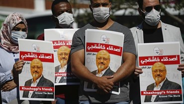 أشخاص يحملون صور خاشقجي بالقرب من مقر القنصلية السعودية في اسطنبول في الذكرى الثانية لمقتله (2 ت1 2020، أ ب). 
