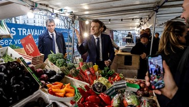 ماكرون يجول في سوق مفتوحة في نويي سور سين بالقرب من باريس (8 نيسان 2022، أ ف ب). 