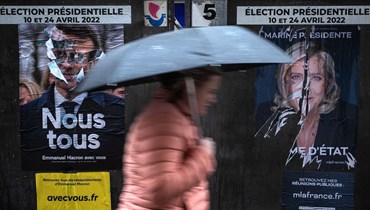 ملصقان للحملة الانتخابية لإيمانويل ماكرون ومارين لوبان في باريس (8 نيسان 2022 - أ ف ب).