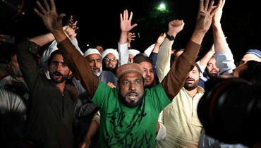 أنصار المعارضة يرددون شعارات ضد خان أمام مبنى البرلمان في إسلام أباد (10 نيسان 2022، أ ف ب). 