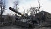رجال وقفوا بجانب دبابة مدمرة في تشيرنيهيف بأوكرانيا (7 نيسان 2022، أ ب).
