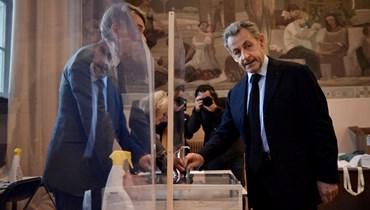 ساركوزي مدليا بصوته في مركز اقتراع في باريس خلال الدورة الأولى من الانتخابات الرئاسية الفرنسية (10 نيسان 2022، ا ف ب). 