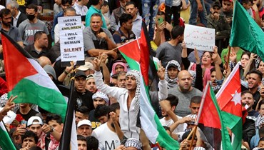 متظاهرون يرفعون العلمين الفلسطيني والأردني خلال مسيرة في شوارع عمان (22 نيسان 2022، أ ف ب). 