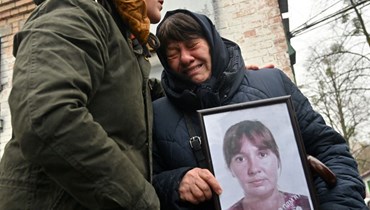 سيدة أوكرانية تبكي ابنتها اليت عُثر على جثتها في آذار في مدينة بوتشا (أ ف ب).