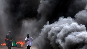 متظاهرون فلسطينيون خلال اشتباكات مع القوات الإسرائيلية في قرية برقة شمال الضفة الغربية المحتلة، في أعقاب احتجاج على مسيرة للمستوطنين الإسرائيليين إلى بؤرة حومش الاستيطانية العشوائية (19 نيسان 2022، ا ف ب). 