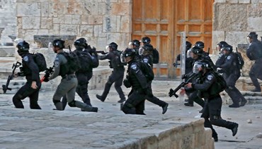 عناصر من قوات الأمن الإسرائيلية تنتشر داخل مجمع المسجد الأقصى في القدس بعد اشتباكات اندلعت مع متظاهرين فلسطينيين (22 نيسان 2022، ا ف ب). 