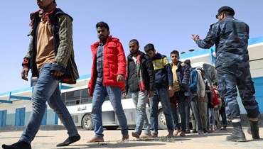 مهاجرون تم اعتراض قاربهم لدى وصولهم الى مركز استقبال بالقرب من العاصمة طرابلس (24 نيسان 2022، أ ف ب). 