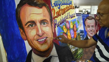 فنان يضفي اللمسات الأخيرة على لوحة للرئيس الفرنسي (أ ف ب). 