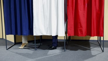 ماكرون وزوجته يقفان في صناديق الاقتراع أثناء تصويتهما للجولة الثانية من الانتخابات الرئاسية الفرنسية (أ ف ب). 