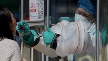 امرأة تخضع لاختبار كشف كورونا في مركز في بيجينغ (26 نيسان 2022، أ ف ب).