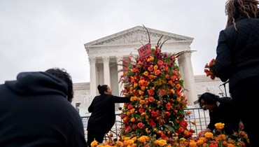 متظاهرون يضعون الزهور أمام مقر المحكمة العليا الأميركية في واشنطن (26 نيسان 2022، أ ف ب). 