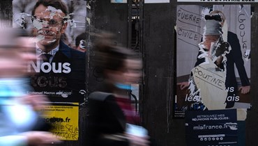 مشهد من باريس وتبدو ملصقات الحملة الانتخابية للرئيس الفرنسي إيمانويل ماكرون والمرشحة الرئاسية مارين لوبن (21 نيسان 2022 - أ ف ب).