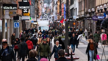 أشخاص يمشون في أحد شوارع التسوق الأكثر ازدحامًا في ستوكهولم (28 نيسان 2022، أ ف ب). 