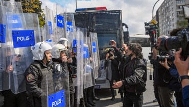شرطيون يمنعون صحافيين من العبور خلال اعتقال متظاهرين في احتجاج عيد العمال بالقرب من ميدان تقسيم في اسطنبول (1 ايار 2022، أ ف ب). 